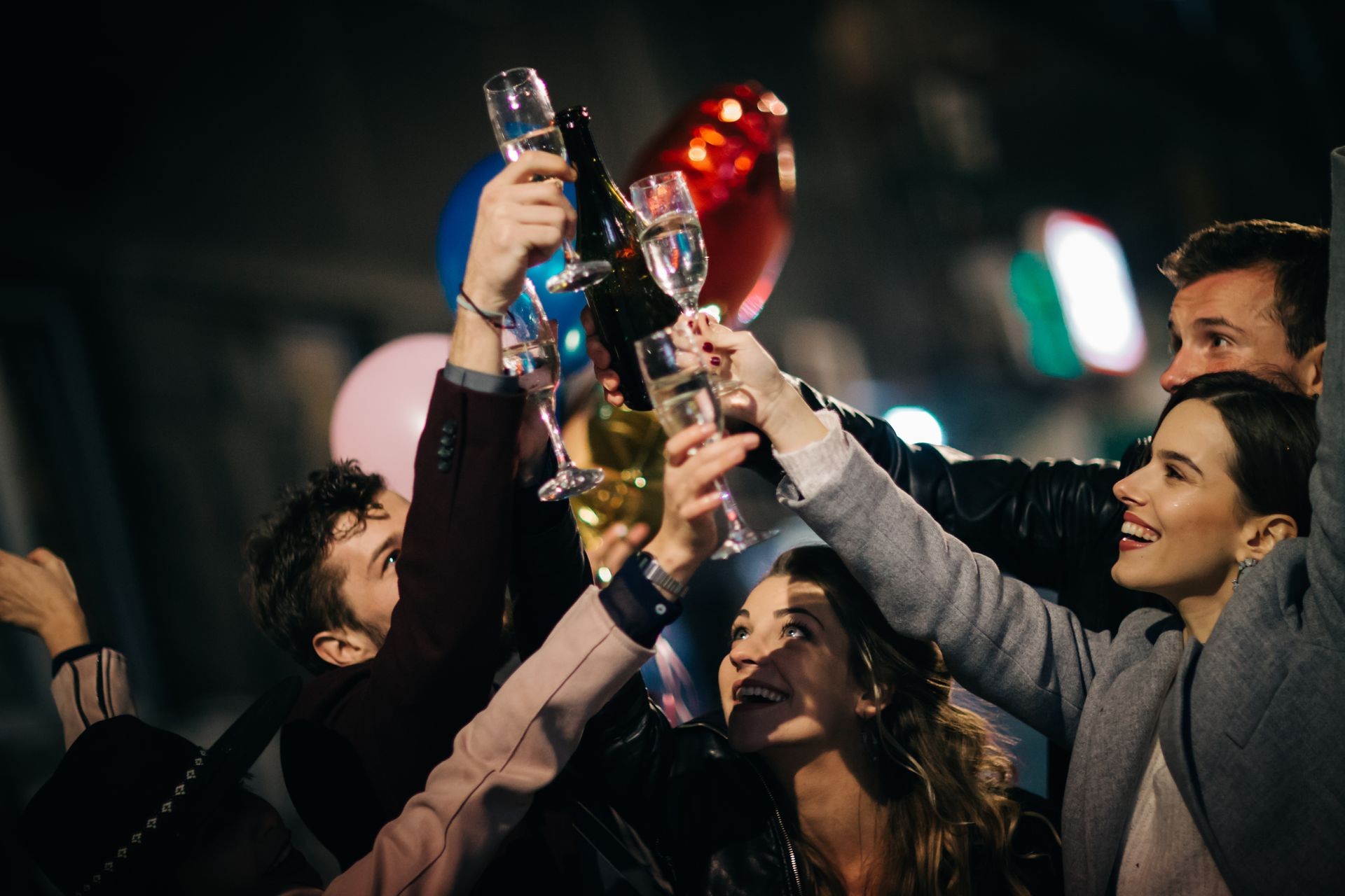 Group of happy friends having fun at the street and drinking champagne. New year party. Birthday party